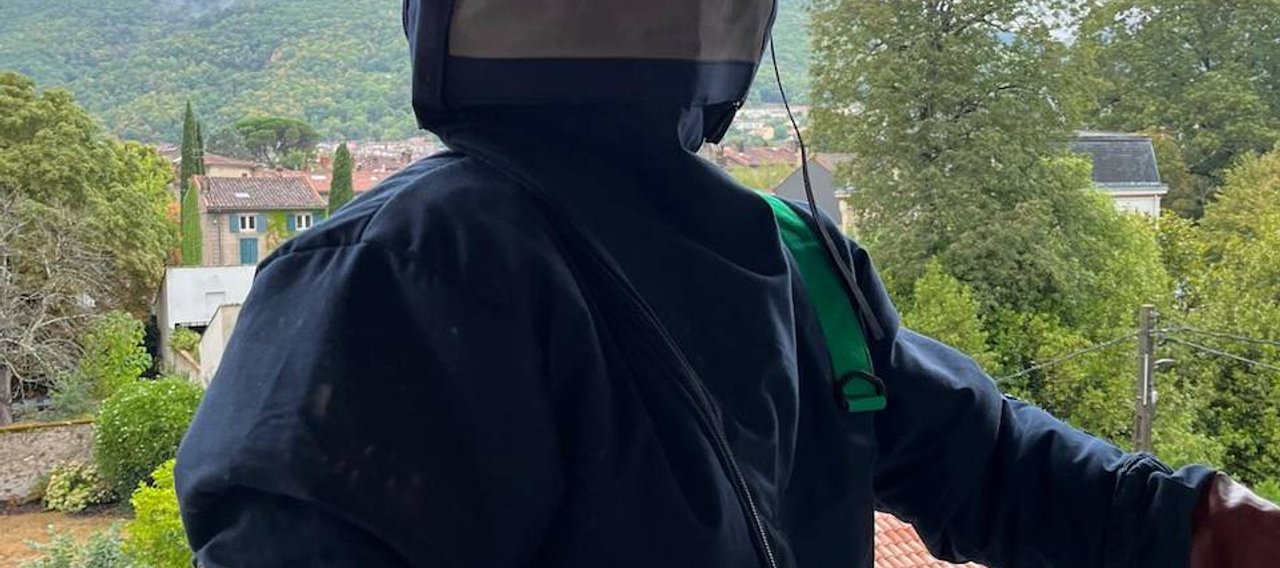 Christophe Guérin en combinaison de protection lors d'une intervention sur un nid de frelons asiatiques, maison de maître à Mazamet