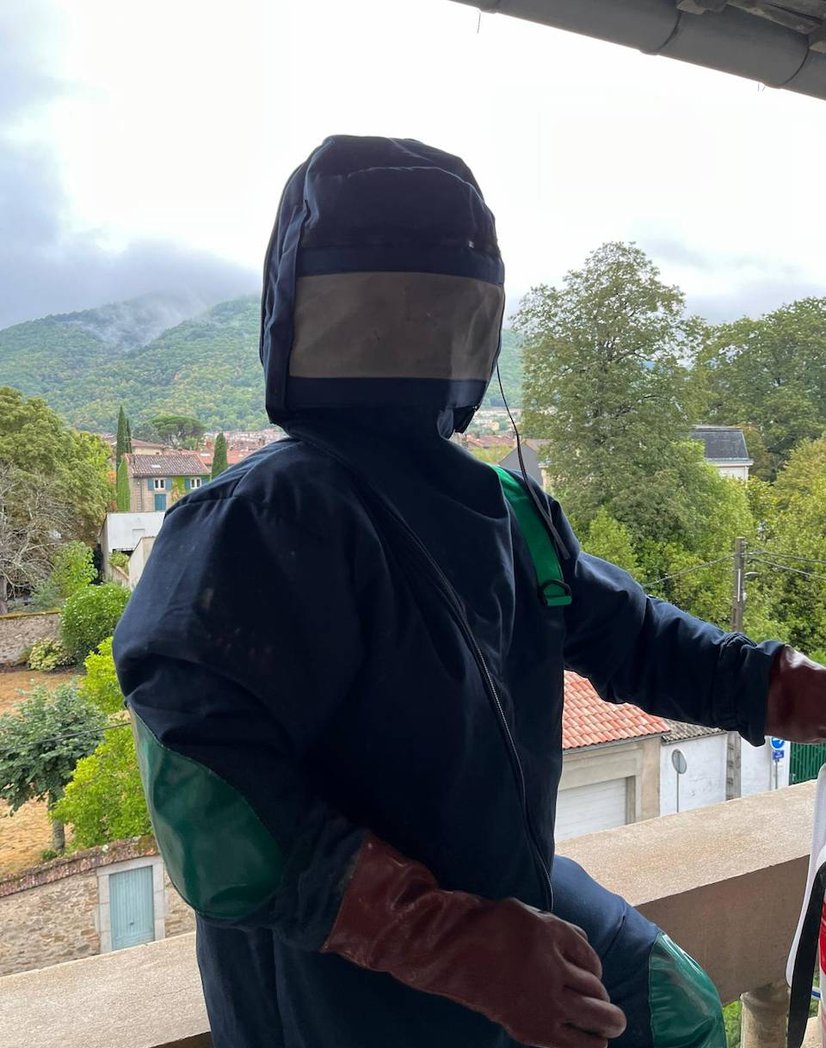 Christophe Guérin en combinaison de protection lors d'une intervention sur un nid de frelons asiatiques, maison de maître à Mazamet